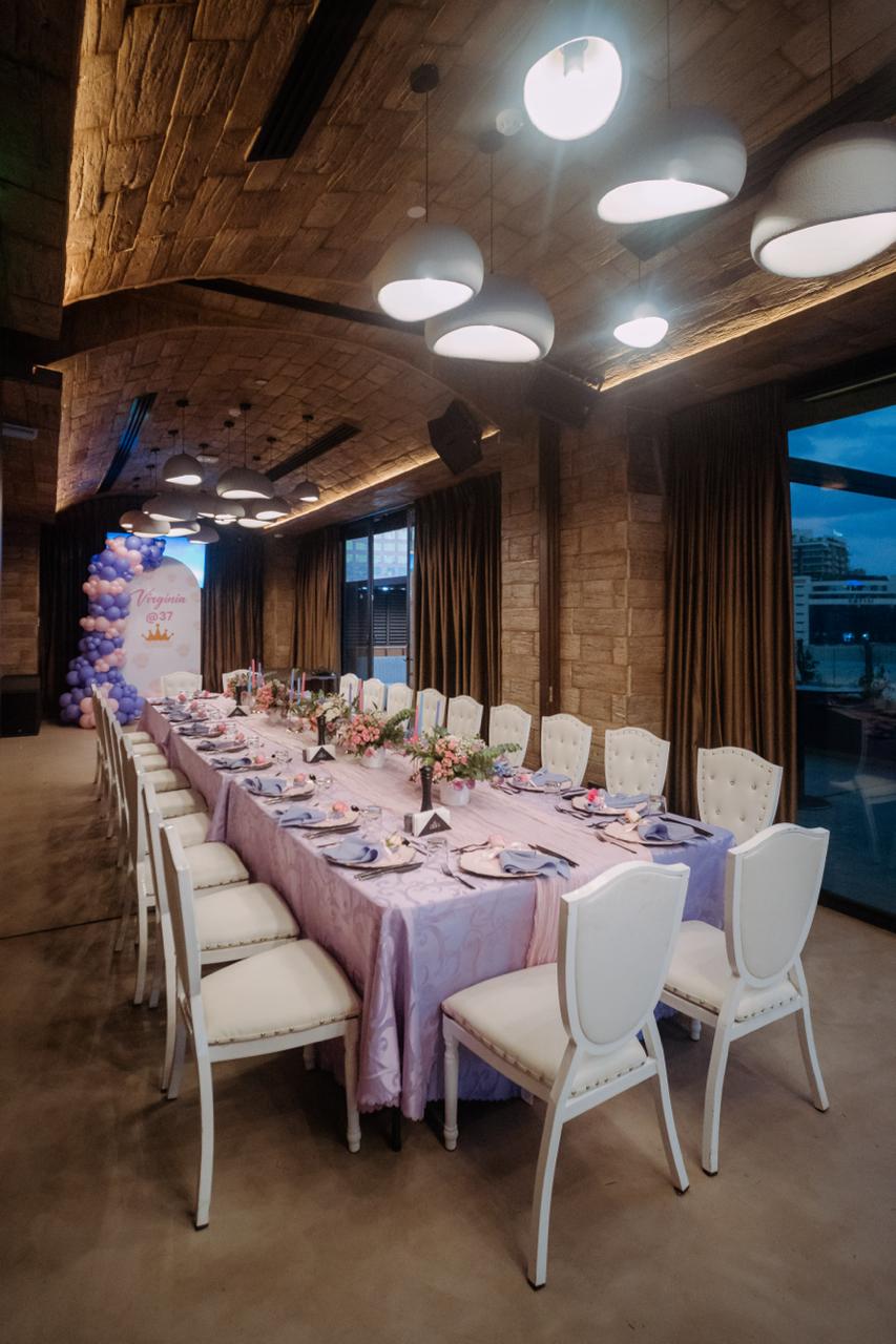Elegant dining setup with purple theme and balloon decorations